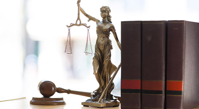 Lady Justice next to books