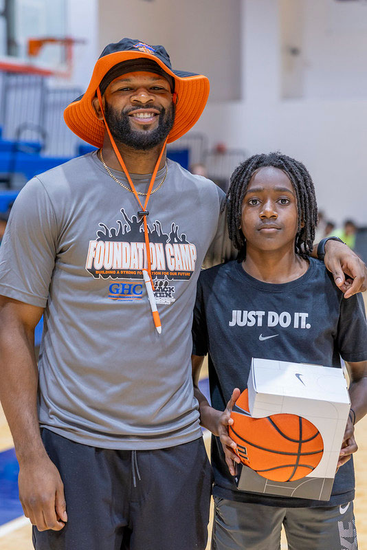 Foundation Camp counselor with camper with basketball prize