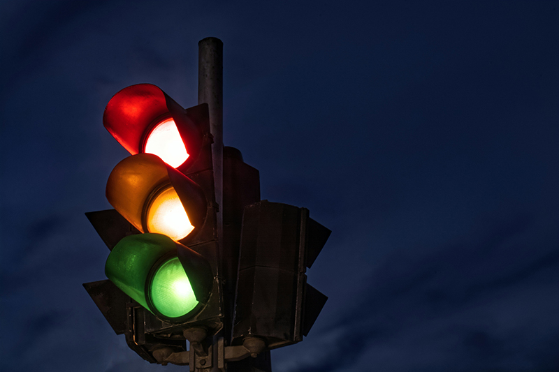 A stoplight with the red, yellow, and green lights lit