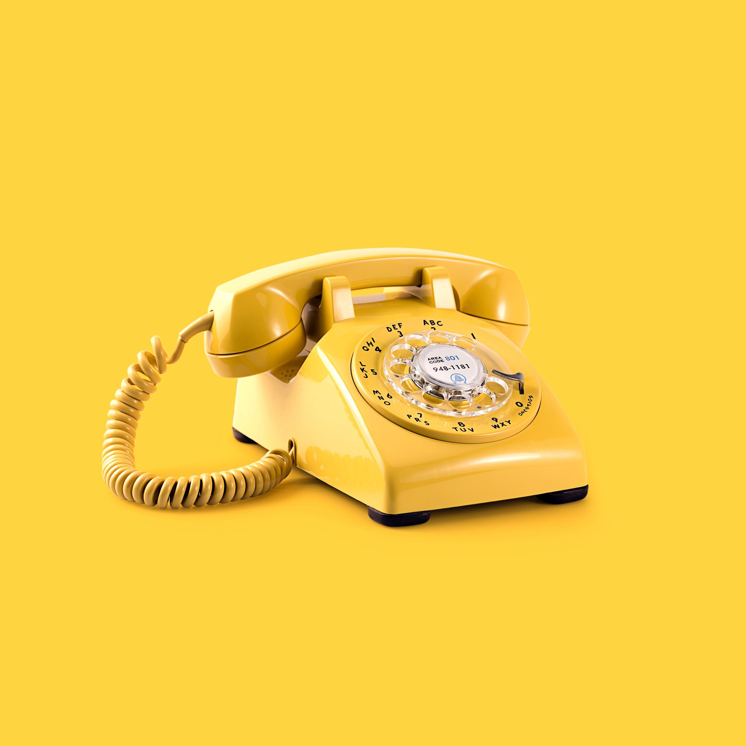 Yellow telephone on yellow background