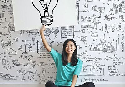 woman holding a drawing of a lightbulb