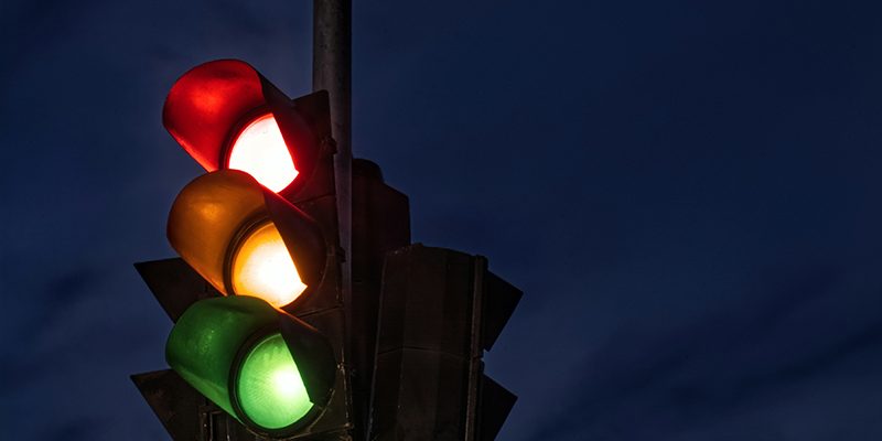 A stoplight with the red, yellow, and green lights lit