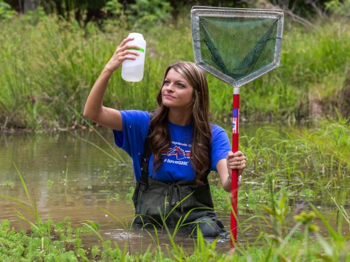 female student with net and bottle doing water testing