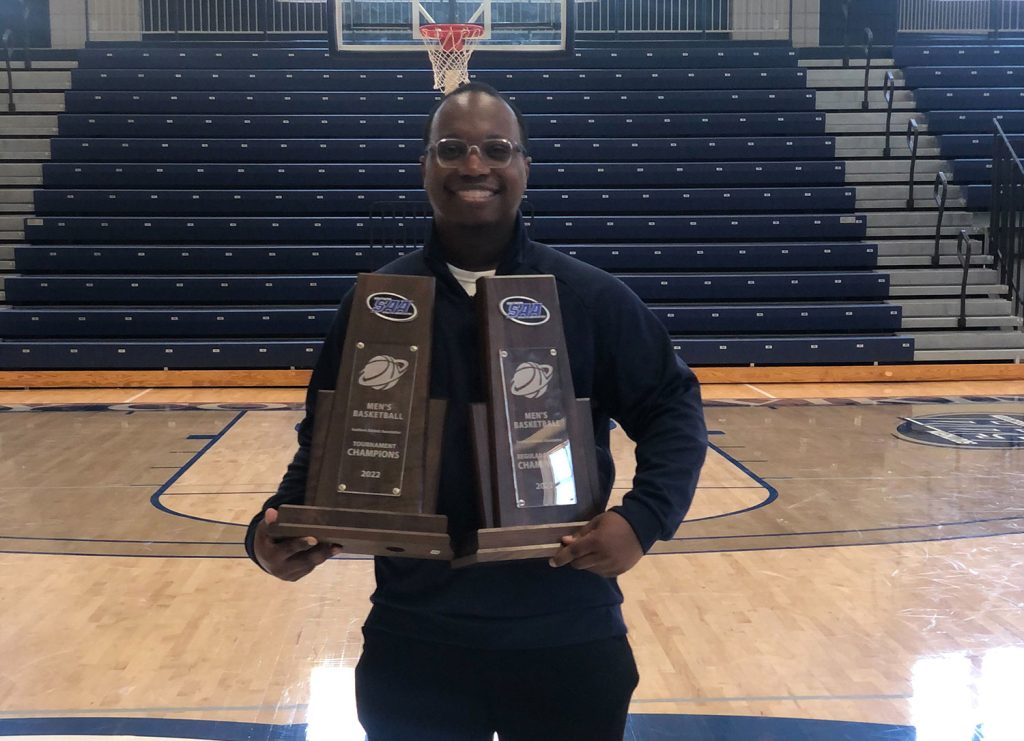 Dominic Weems holding basketball trophies