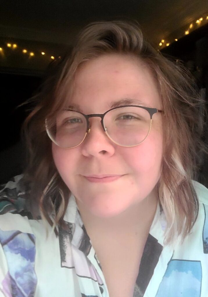 Woman with shoulder-length hair and glasses smiling